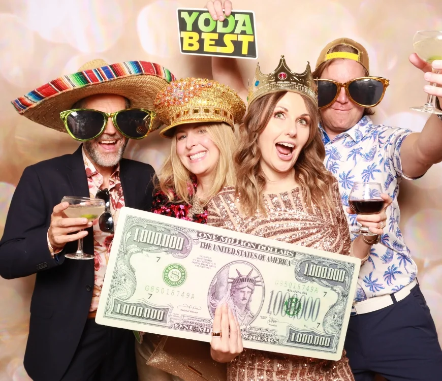 Guests posing with oversized sunglasses and crowns at a CaptureME photo booth rental
